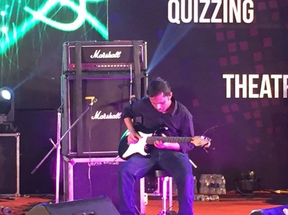 Rahul playing a Stratocaster on stage in front of a Marshall stack